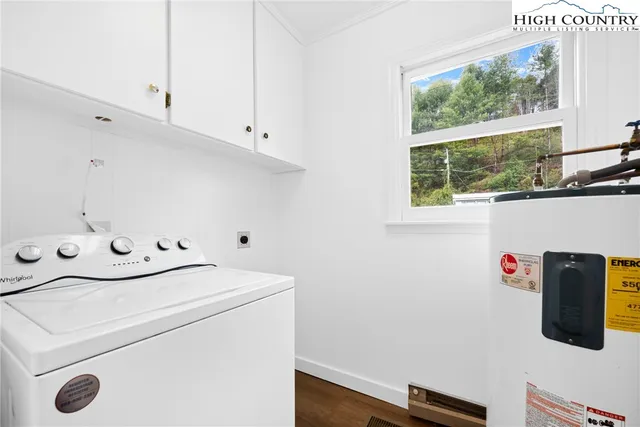 a bedroom with a bed chandelier and a window