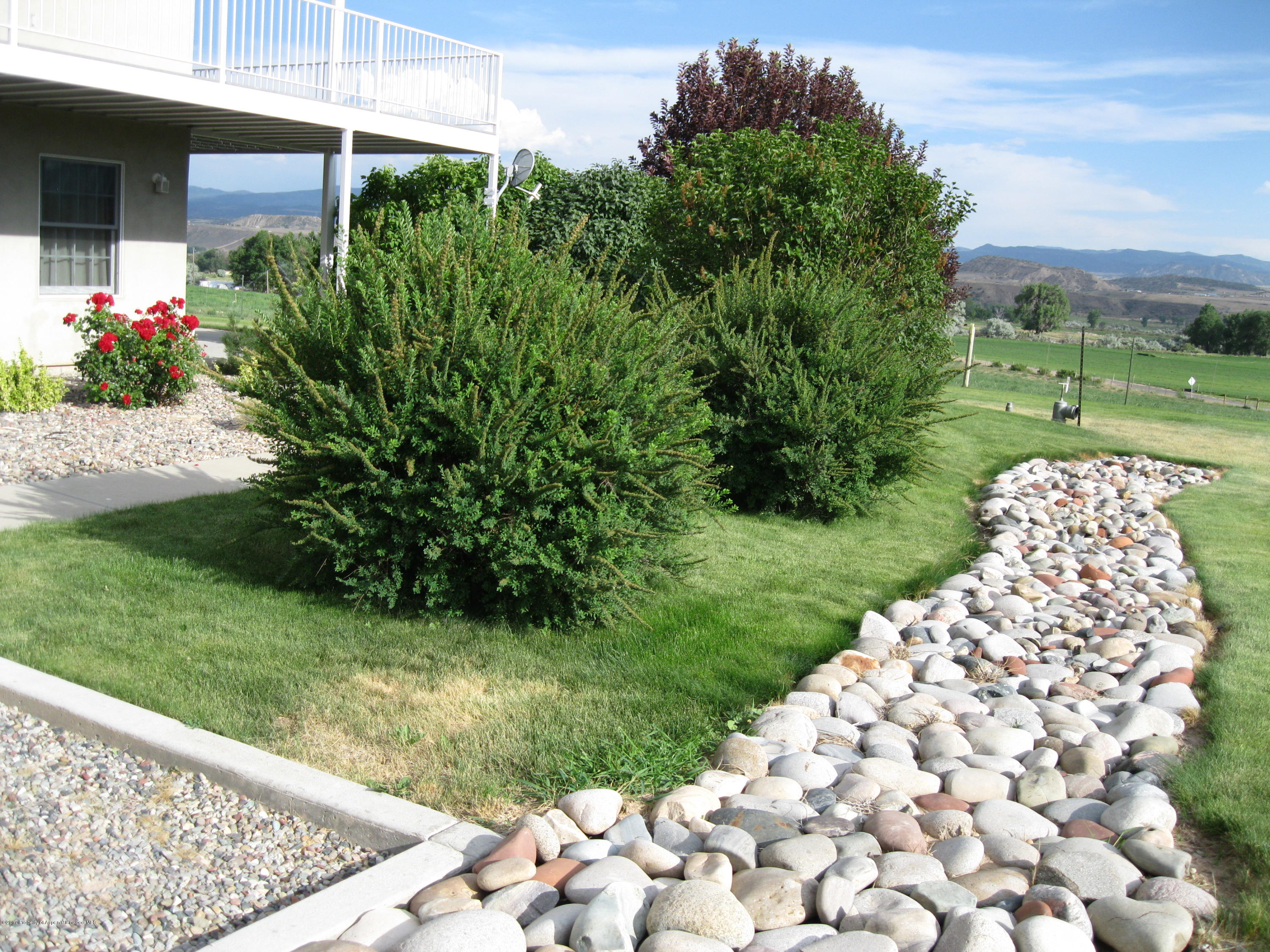2989 County Road 210 Rifle, CO 81650 - Photo 5 of 22 a garden with flowers in front of it