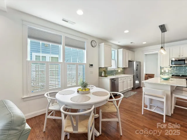 a kitchen with a dining table chairs and refrigerator