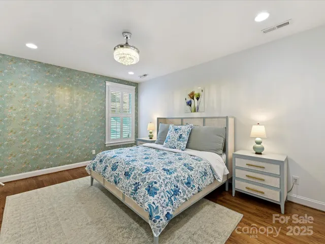 a bedroom with a bed a dresser and window