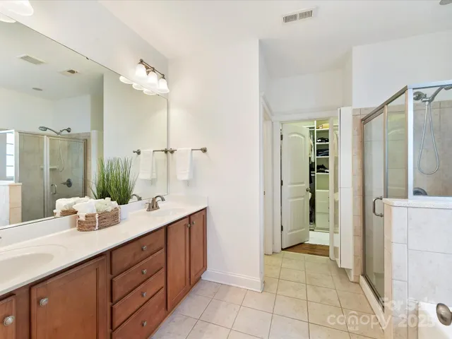 a spacious bathroom with a double vanity sink mirror and shower