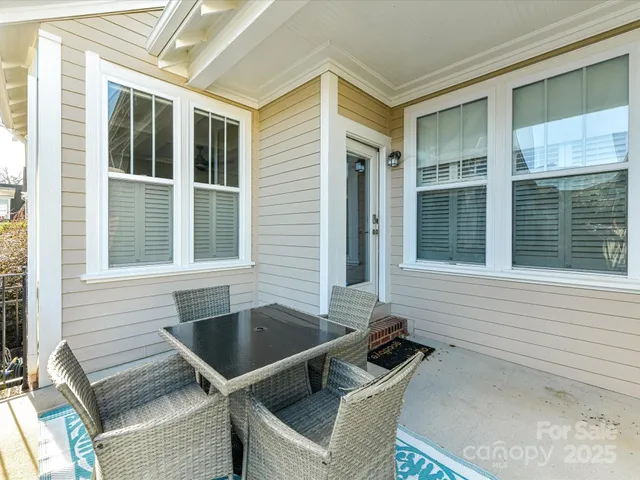 a view of a chair and table in the back room of the house