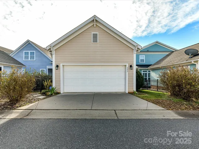 a front view of a house with yard and parking