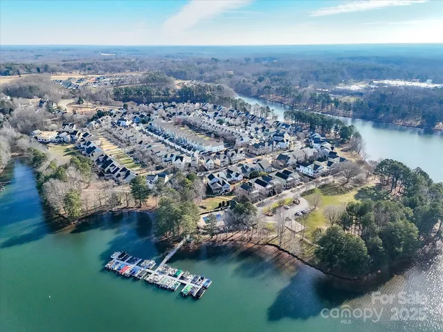 an aerial view of residential houses with outdoor space and lake view