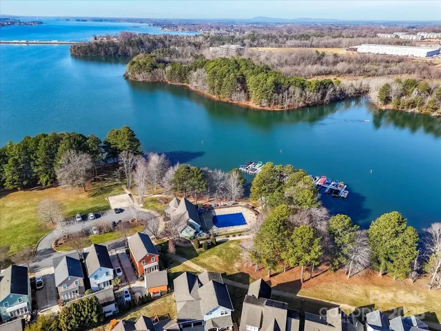 an aerial view of residential houses with outdoor space and lake view