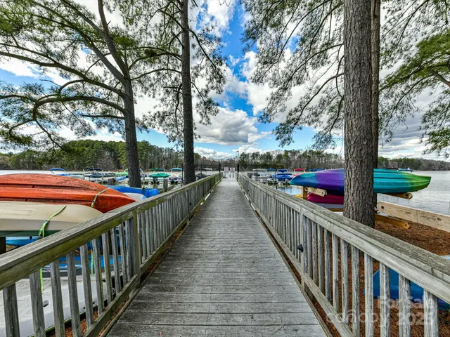 a view of a balcony with wooden floor and trees