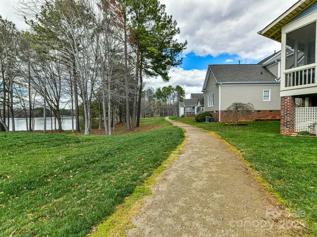 a view of a white house with a big yard and large tree