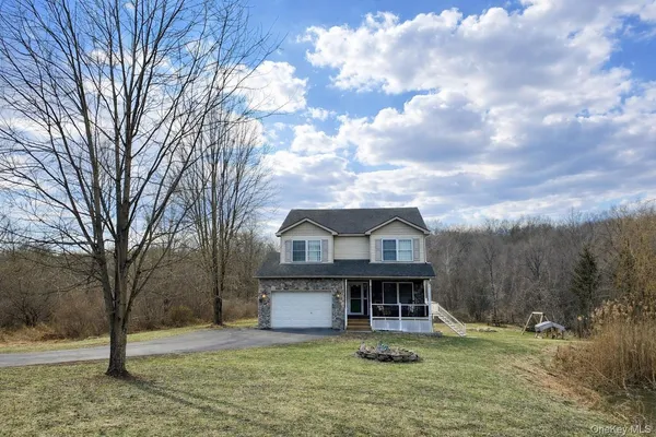 a view of a big house with a big yard and large tree