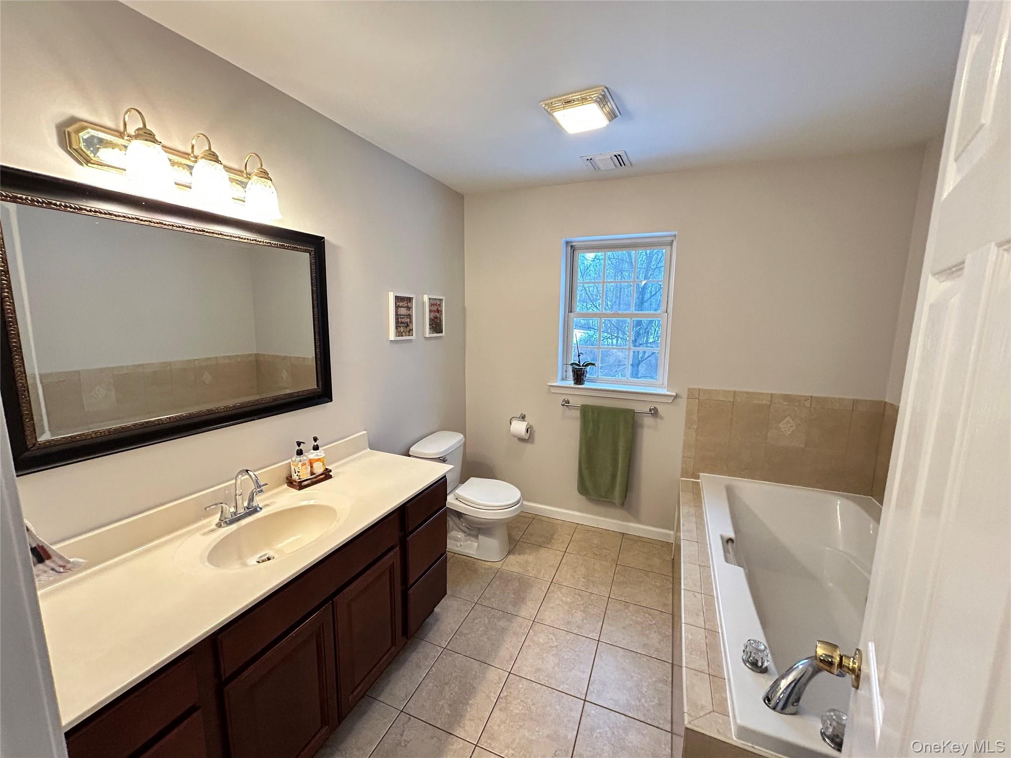 53 Daly Road Middletown, NY 10940 - Photo 15 of 27 a spacious bathroom with a double vanity sink a mirror and a toilet