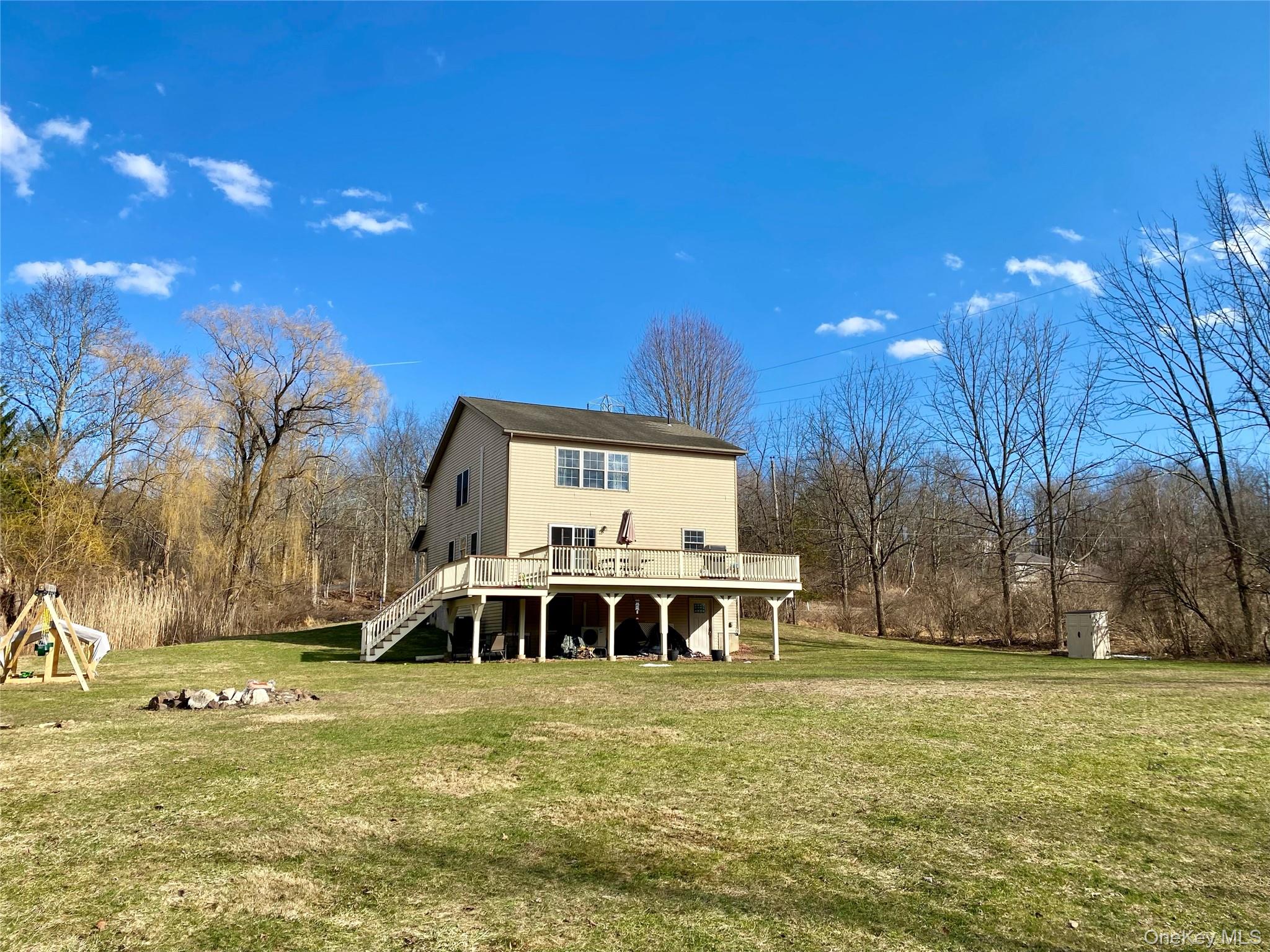 53 Daly Road Middletown, NY 10940 - Photo 26 of 27 a view of a swimming pool with lawn chairs under an umbrella with palm trees