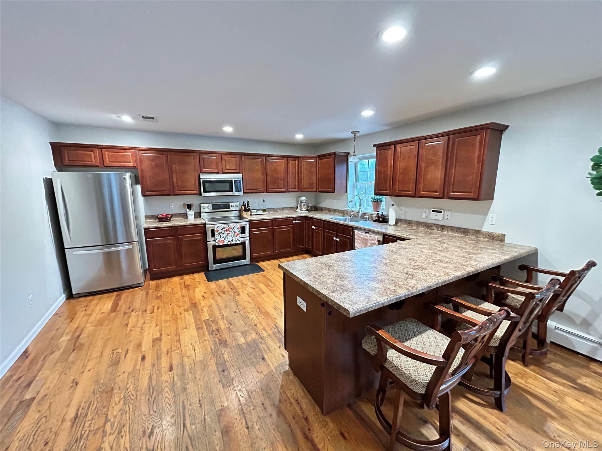 53 Daly Road Middletown, NY 10940 - Photo 8 of 27 a kitchen with stainless steel appliances granite countertop a stove top oven a sink dishwasher a dining table and chairs with wooden floor