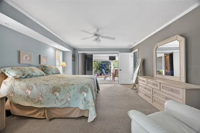 a spacious bedroom with a bed a mirror and a large window