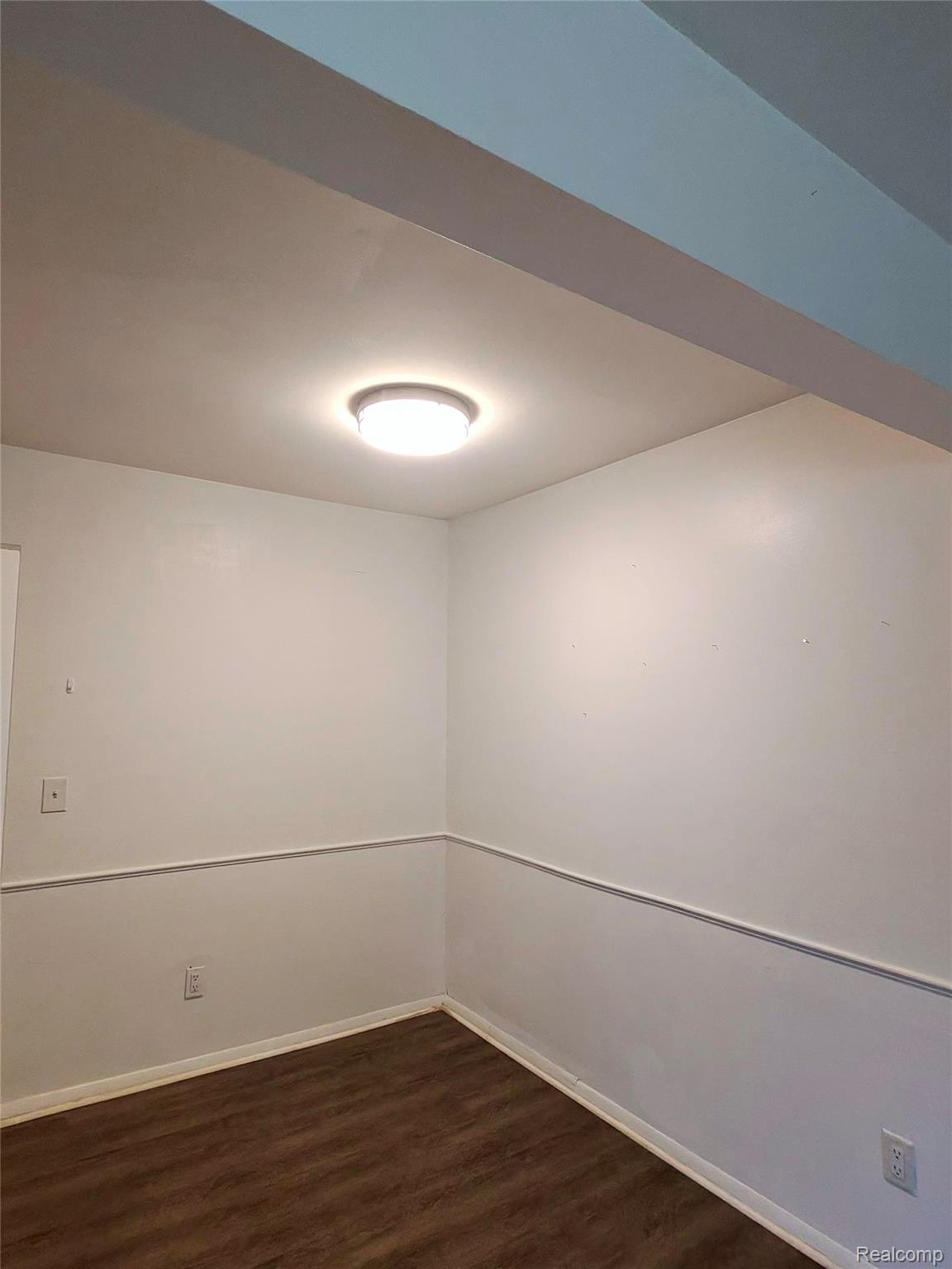 25301 Five Mile Road, Unit 130 Redford, MI 48239 - Photo 12 of 15 Room featuring wood-finish flooring, white walls, chair rail molding, a flush-mount ceiling light, and white baseboards