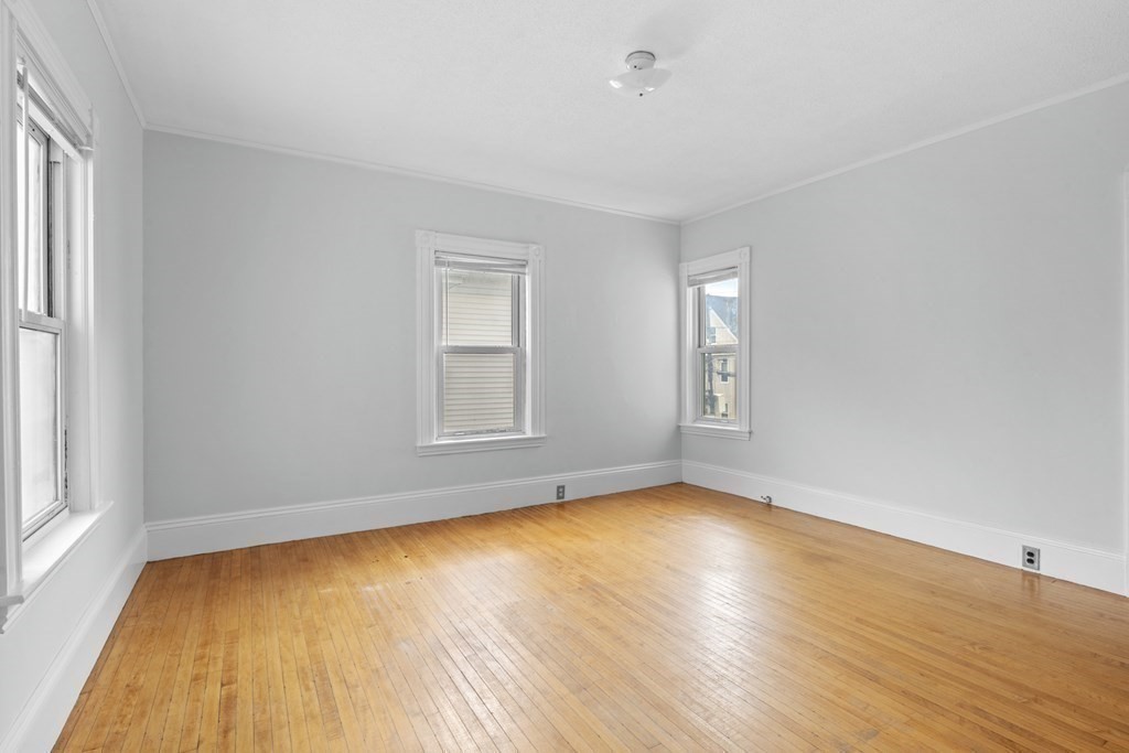 47 Cedar Street Malden, MA 02148 - Photo 15 of 24 an empty room with wooden floor and windows