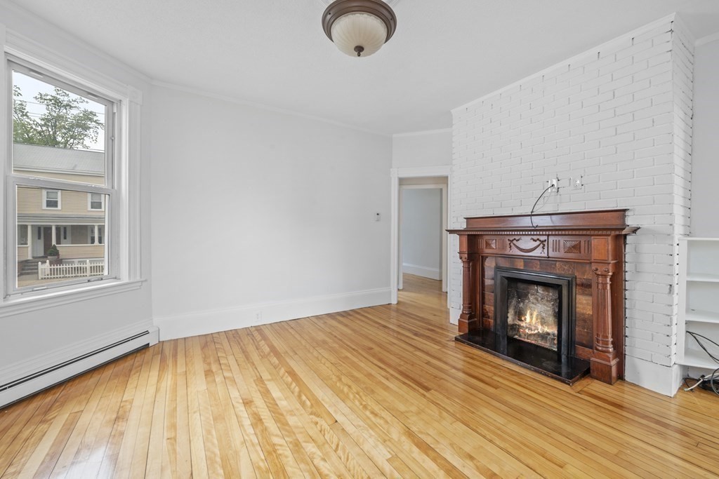 47 Cedar Street Malden, MA 02148 - Photo 8 of 24 a view of empty room with wooden floor and fireplace