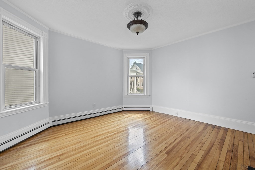 47 Cedar Street Malden, MA 02148 - Photo 9 of 24 an empty room with wooden floor and windows