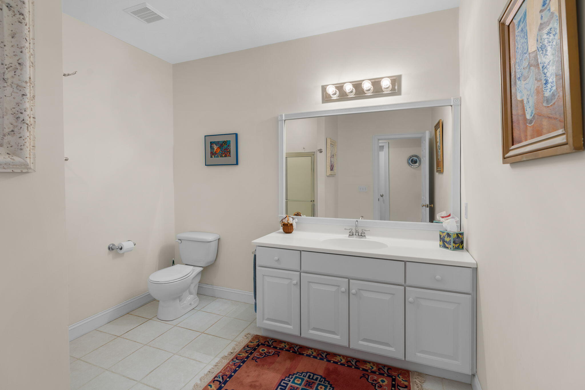 208 Rock Landing Road Mashpee, MA 02649 - Photo 16 of 32 a spacious bathroom with a toilet a sink and a mirror