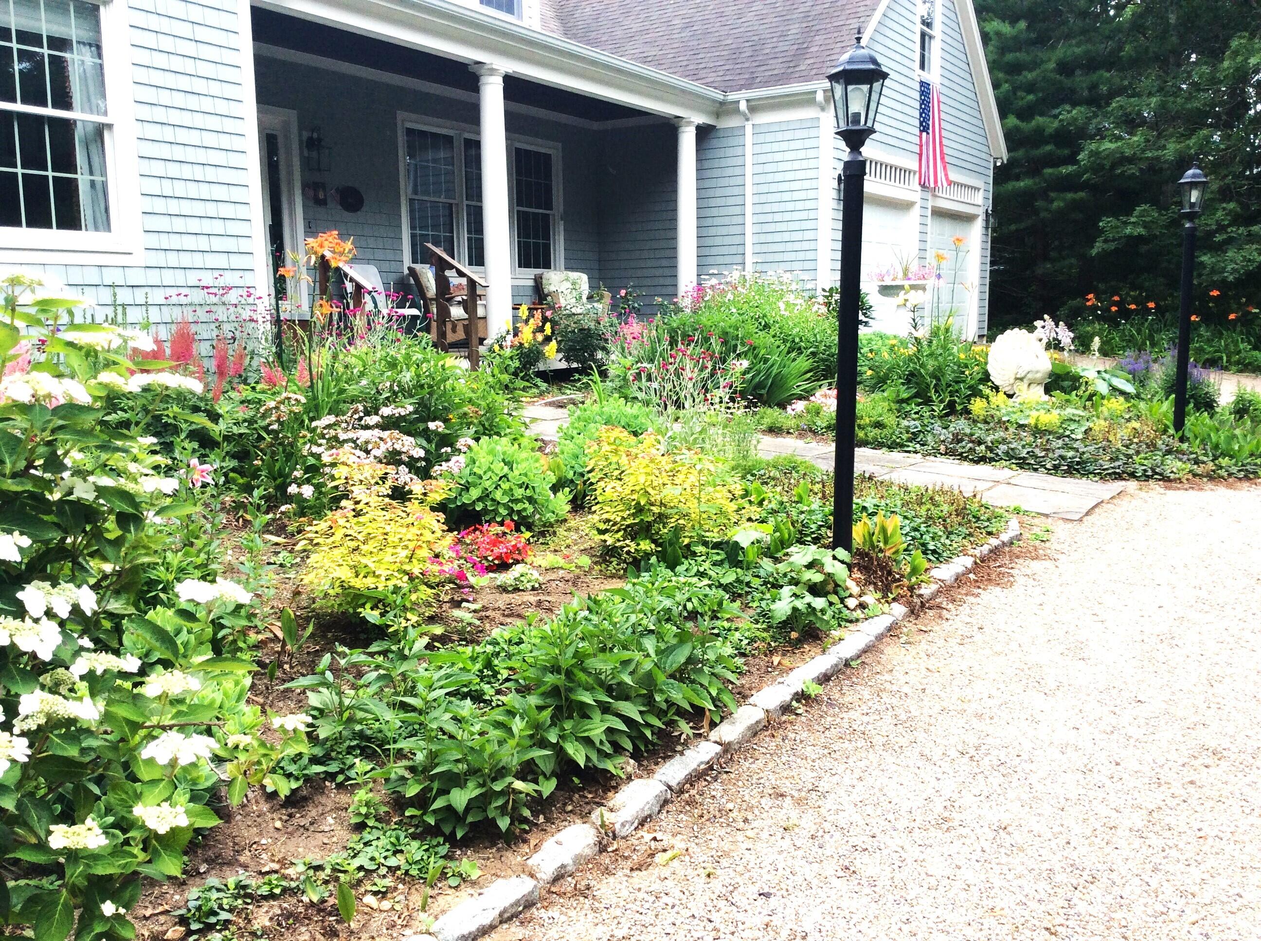 208 Rock Landing Road Mashpee, MA 02649 - Photo 3 of 32 a front view of a house with a yard and potted plants