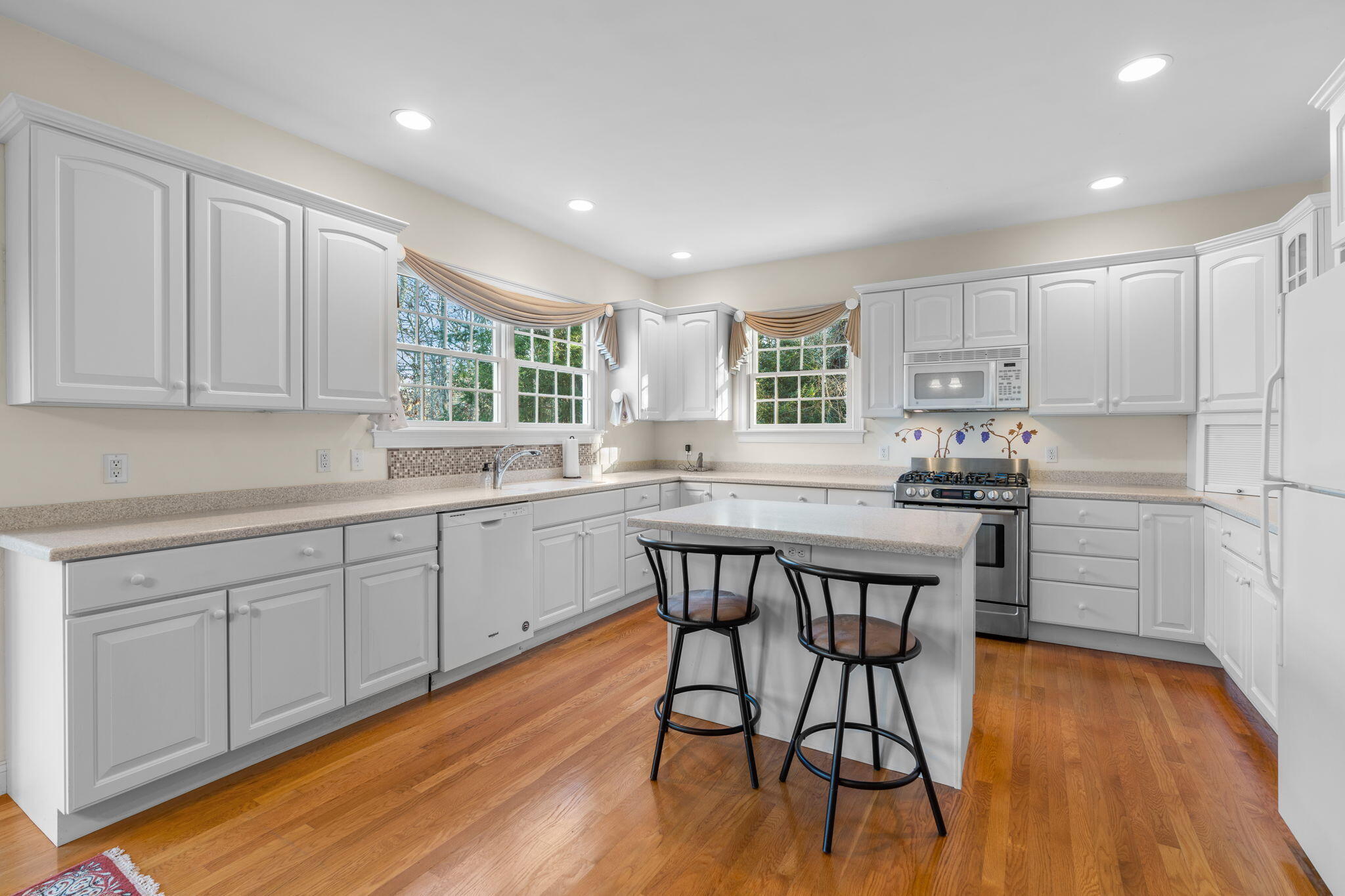 208 Rock Landing Road Mashpee, MA 02649 - Photo 5 of 32 a kitchen with stainless steel appliances granite countertop wooden floor window and cabinets