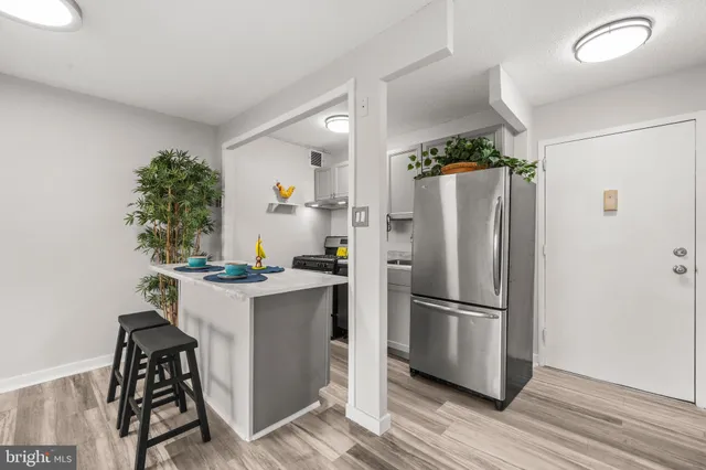 a kitchen with a refrigerator and a stove top oven