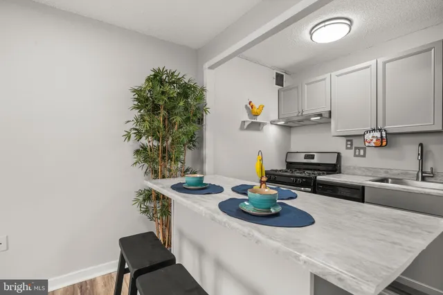 a kitchen with a sink a stove and chairs