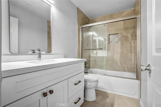 a bathroom with a shower sink vanity mirror and toilet