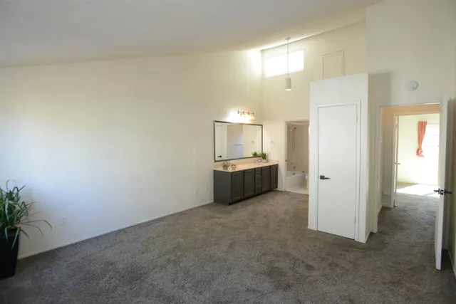 a spacious bedroom with a large mirror and shower