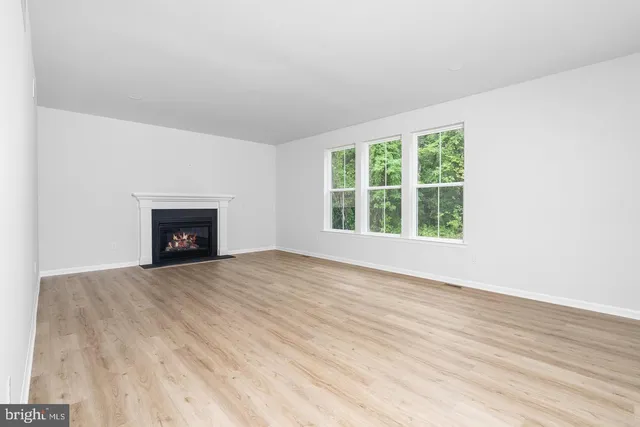 an empty room with wooden floor and a window