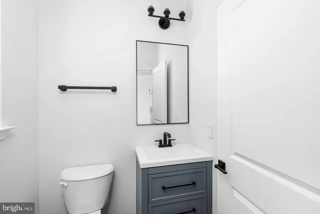 a bathroom with a sink a toilet and mirror