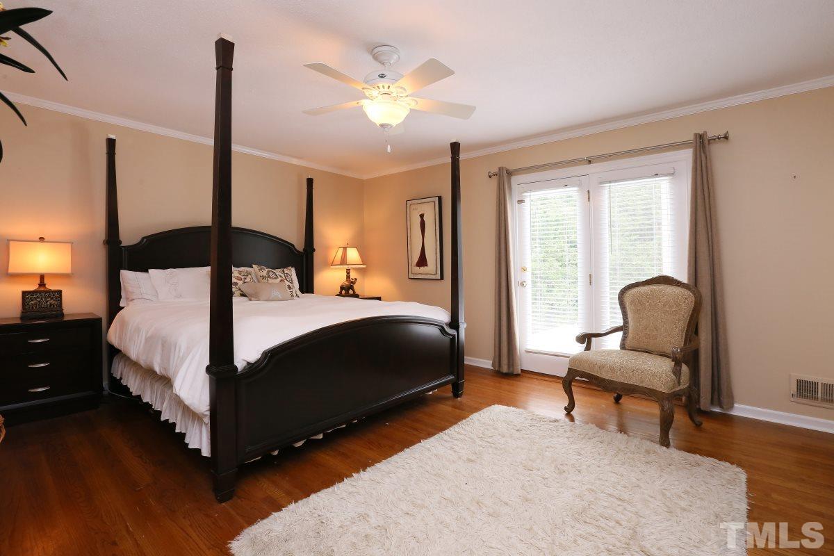 1013 Deerfield Road Raleigh, NC 27609 - Photo 4 of 25 a bedroom with a bed and a chandelier