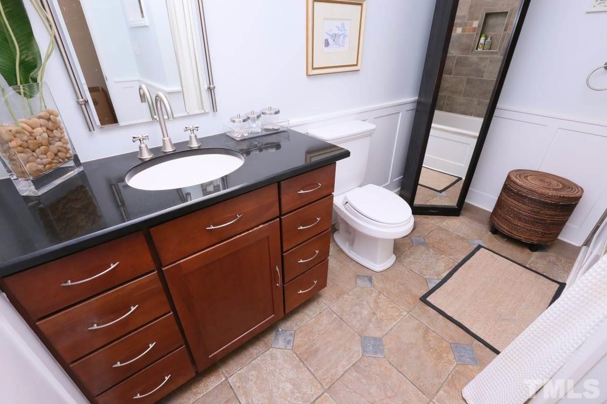 1013 Deerfield Road Raleigh, NC 27609 - Photo 6 of 25 a bathroom with a granite countertop sink and a mirror