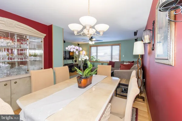 a living room with dining table furniture a chandelier and a large window