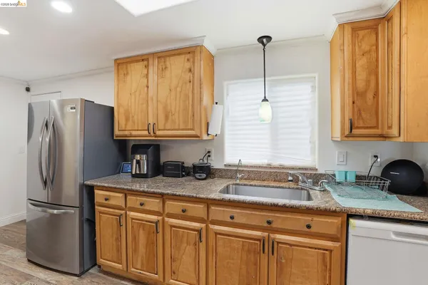 a kitchen with stainless steel appliances granite countertop a sink a refrigerator a center island and cabinets