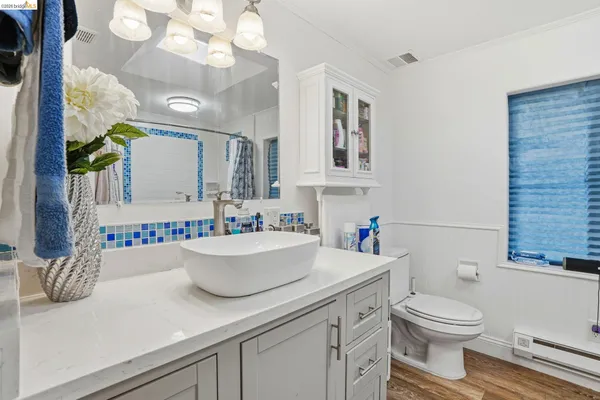 a bathroom with a sink a toilet and a mirror