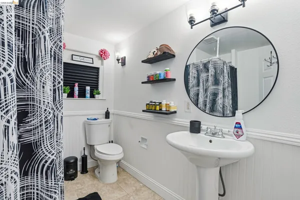 a bathroom with a sink a toilet and a mirror