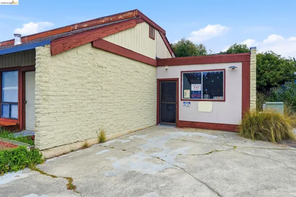 a view of a house with a yard and potted plants