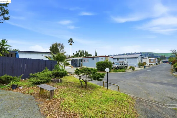 a swimming pool with barbeque oven table and chairs