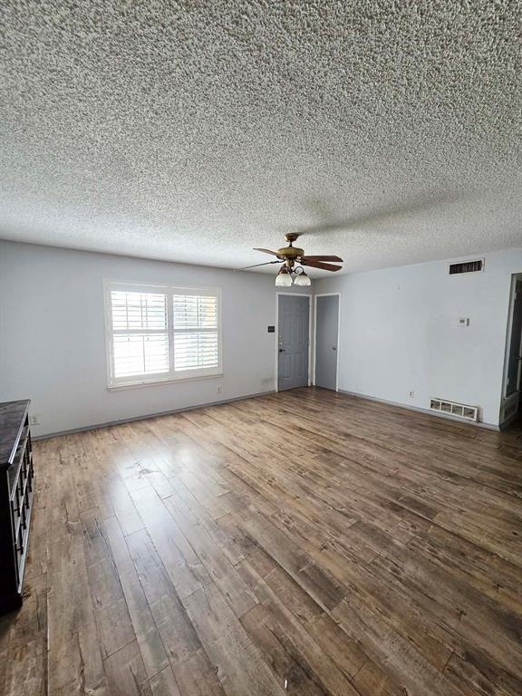 722 South Church Street Pilot Point, TX 76258 - Photo 7 of 37 an empty room with wooden floor and windows
