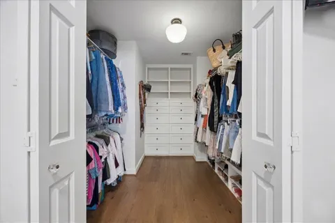a view of walk in closet with clothes