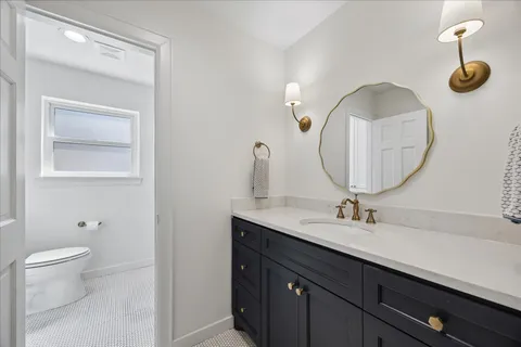 a bathroom with a toilet a sink and mirror