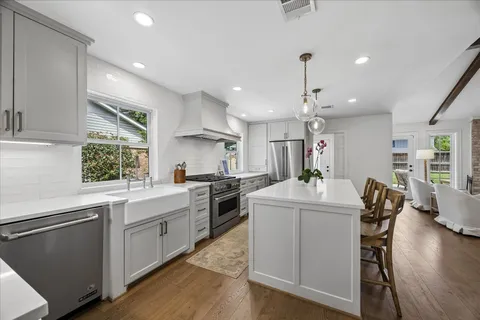 a kitchen with counter top space sink stove and wooden floor