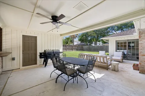 a view of a patio with a table chairs and a backyard