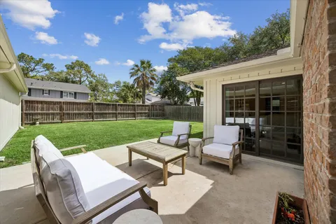 a view of a patio with couches chairs and a yard