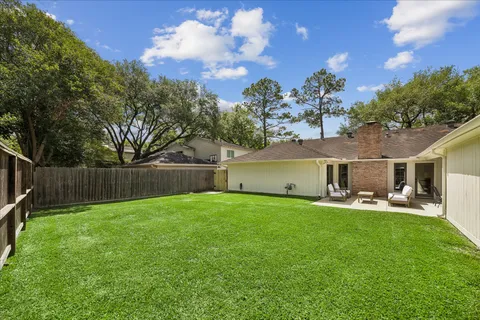 a front view of house with yard and trees in the background