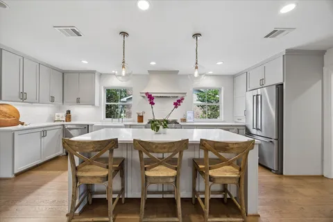 a kitchen with stainless steel appliances granite countertop white cabinets and wooden floor