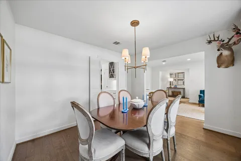 a view of a dining room with furniture wooden floor and chandelier