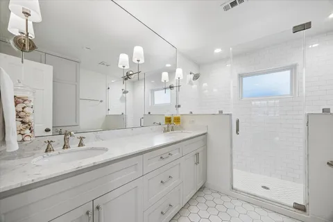 a bathroom with a sink a vanity a large mirror and shower