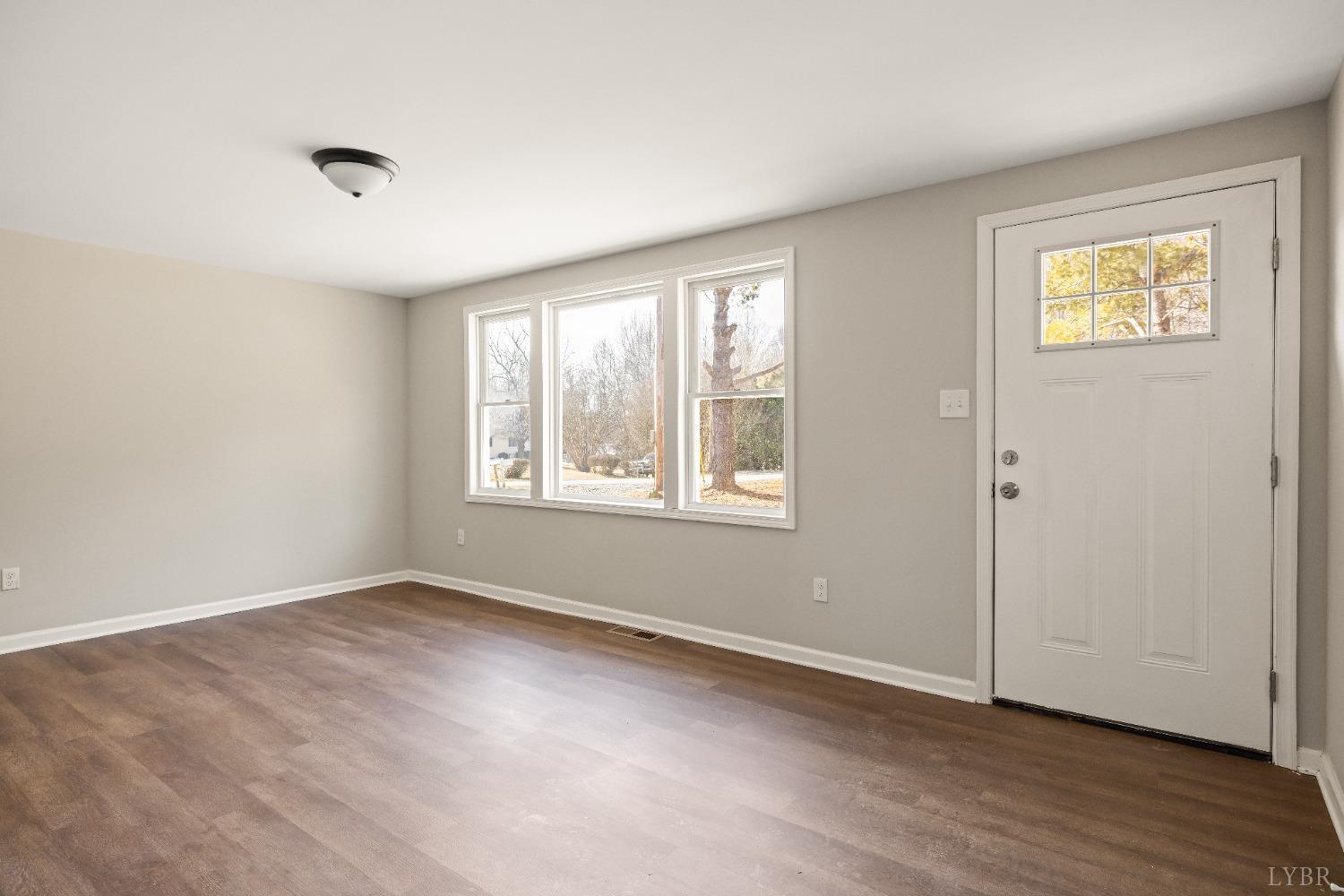 3936 Goodview Road Goodview, VA 24095 - Photo 12 of 29 a view of an empty room with wooden floor and a window