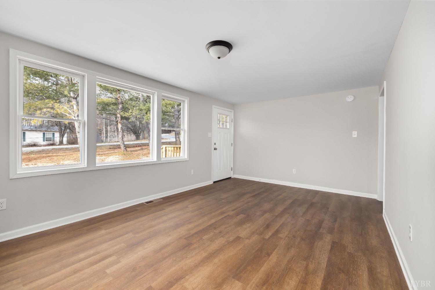 3936 Goodview Road Goodview, VA 24095 - Photo 13 of 29 a view of an empty room with wooden floor and a window