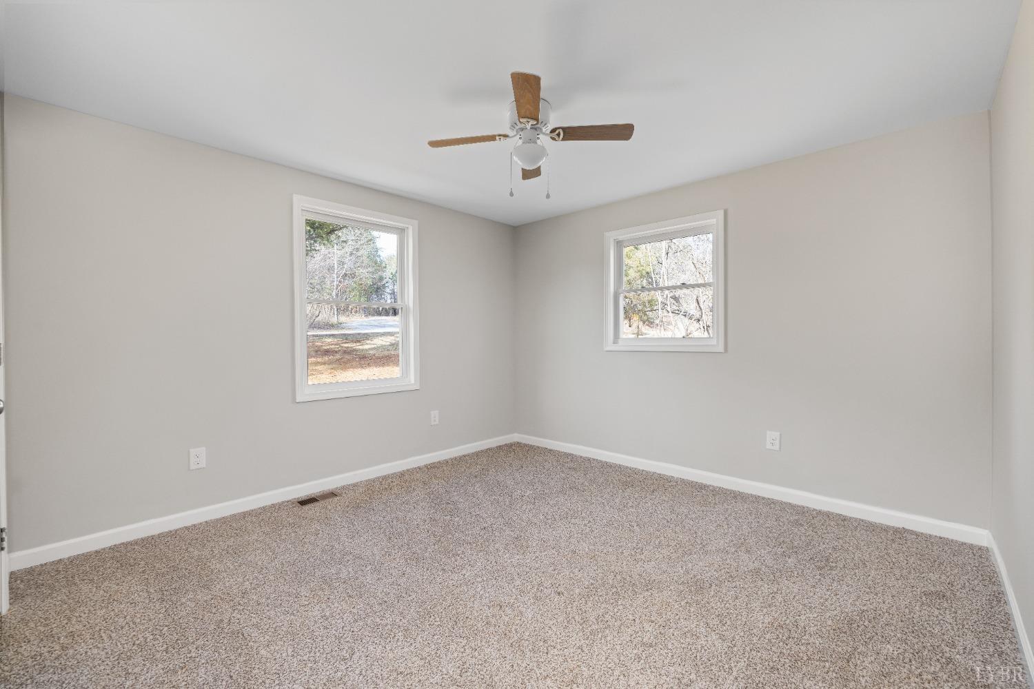 3936 Goodview Road Goodview, VA 24095 - Photo 20 of 29 an empty room with windows and ceiling fan